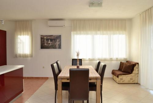 a dining room with a table and chairs and a couch at Apartments Lorenco in Brela