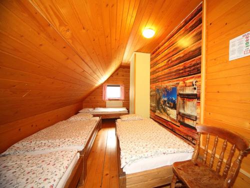 a room with two beds in a wooden cabin at PLANINSKA KOČA NA GOZDU in Kranjska Gora