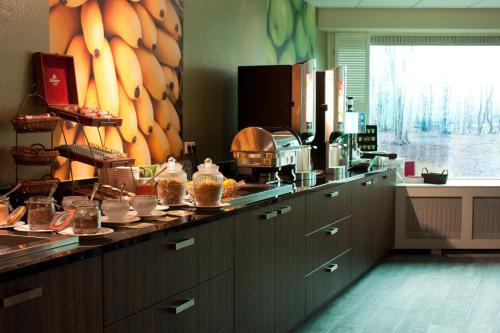 a kitchen with a counter with food on it at Hotel Hof van Gelre by Flow in Lochem