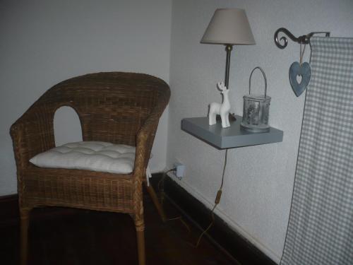 a room with a chair and a lamp on a shelf at Gite En Alsace in Rouffach
