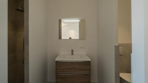 une salle de bain avec un lavabo et un miroir dans l'établissement Les Terrasses de Cascavelle, à Blauvac