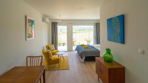 - un salon avec un lit et une chambre avec une table dans l'établissement Les Terrasses de Cascavelle, à Blauvac