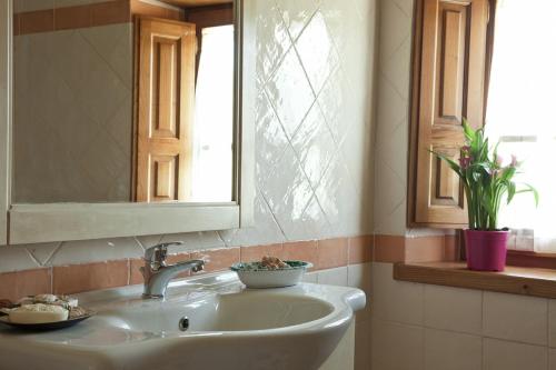 a bathroom with a sink and a mirror and a window at Antico Casale di Ferdinandi in Bibbiena