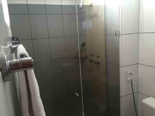 La salle de bains est pourvue d'une douche avec une porte en verre. dans l'établissement Flat 804 Paradise Flat, à Natal