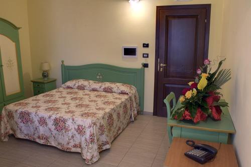 - une chambre avec un lit et des fleurs sur une table dans l'établissement Agriturismo Sant' Isidoro, à Anagni