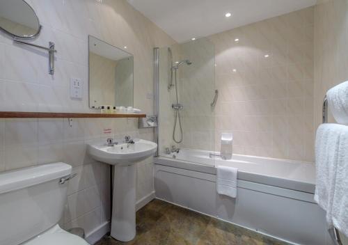 a bathroom with a sink and a toilet and a bath tub at Atholl Hotel in Aberdeen