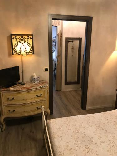 a bedroom with a dresser and a mirror and a door at “La maison” nel cuore di Genova in Genova