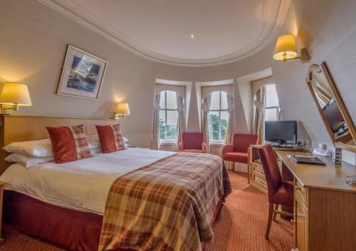 een hotelkamer met een bed, een bureau en stoelen bij Atholl Hotel in Aberdeen