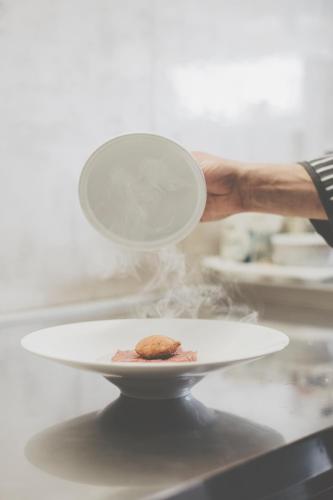 a person holding a plate with a cookie on it at Hotel Residence Giardini in Piode