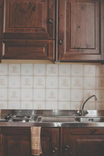 a kitchen with wooden cabinets and a sink at Hotel Residence Giardini in Piode