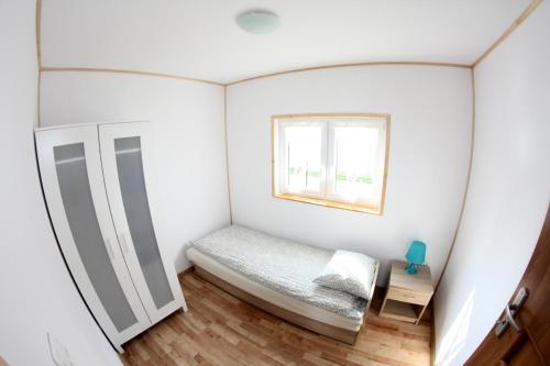 a small bedroom with a bed and a window at Rodzinna Kraina in Ustka