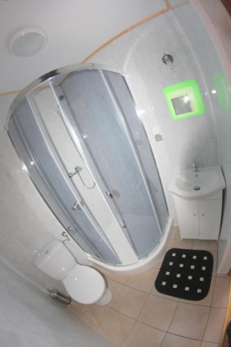 a bathroom with a shower and a sink and a mirror at Rodzinna Kraina in Ustka