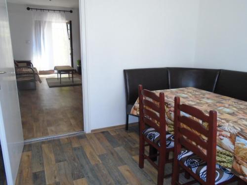 a dining room with a table and chairs and a kitchen at Privát Szállás Miskolctapolca in Miskolctapolca
