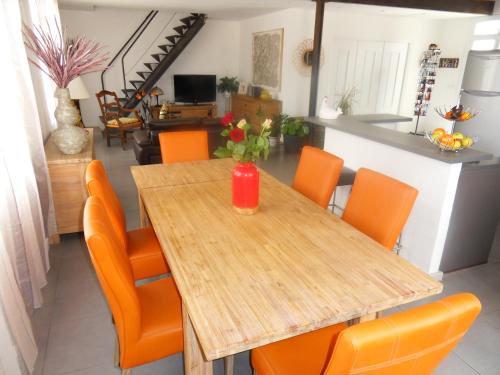 een eetkamer met een houten tafel en oranje stoelen bij SETE BELLE MAISON DE VILLE 121 m2 A 2 mn DE LA PLAGE AVEC JACUZZI in Sète