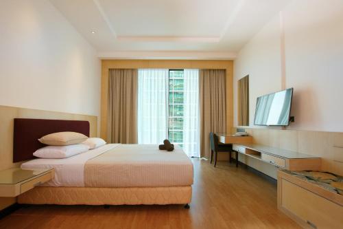 a bedroom with a bed and a desk and a television at Bernard Holiday Home 2 @ Boulevard Imperial Suite Kuching in Kuching