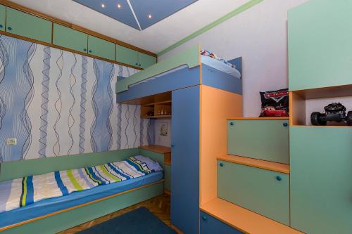 a childs bedroom with a bunk bed and shelves at Апартамент Бриз in Burgas City