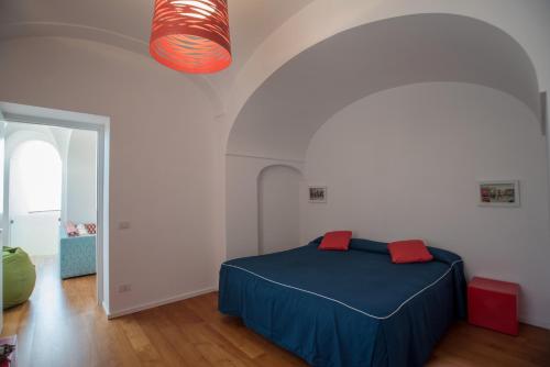 ein Schlafzimmer mit einem blauen Bett in einem weißen Zimmer in der Unterkunft Villa Theile in Positano