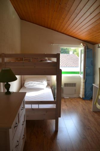 une chambre avec un lit superposé et une fenêtre dans l'établissement Pavillon des Loritz, à Grand-Village-Plage