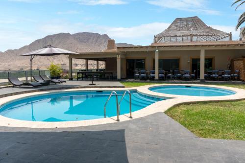 una piscina resort con mesa y sillas en Empedrada Ranch & Lodge - Hotel Asociado Casa Andina, en Caral