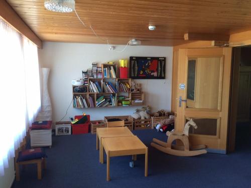 a childs play room with a table and chairs at Hotel Meielisalp in Leissigen