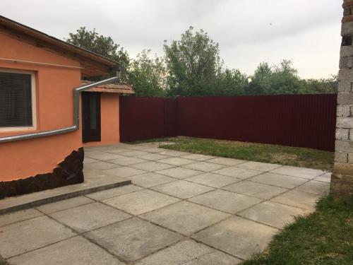 a backyard with a red fence and a sidewalk at Sadyba u Mykhaila in Kosonʼ