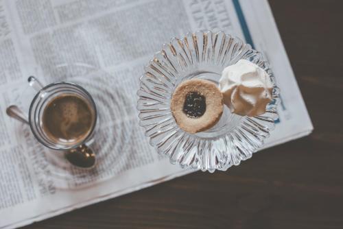a donut and a cup of coffee on a newspaper at Hotel Residence Giardini in Piode
