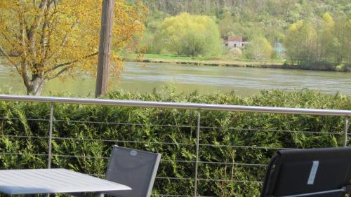a table and chairs sitting next to a river at Les Terrasses sur Seine in Vernon