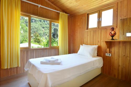 a bedroom with a bed in a room with windows at Arcadia Villas in Cıralı