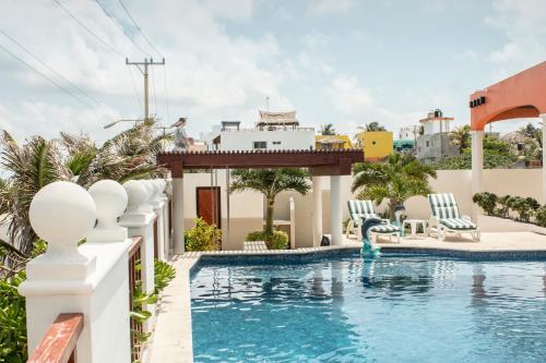 a pool at a resort with chairs and a swimming pool at Villa Isla Dorada in Isla Mujeres