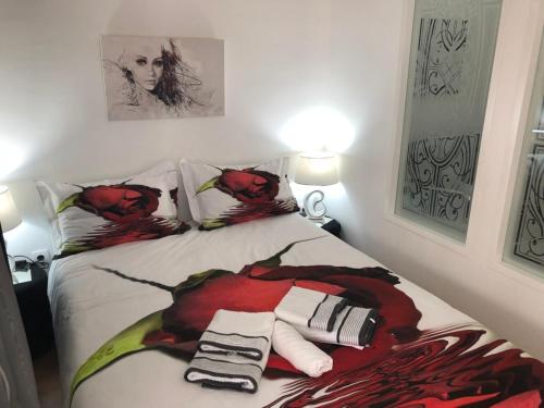 Apartman Jezdić في بانيا كوفيلياتشا: غرفة نوم عليها سرير وورد احمر