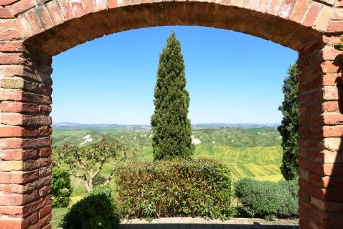 カセッタにあるTuscany Balcony: Crete Senesiのレンガ窓越しの木の景色