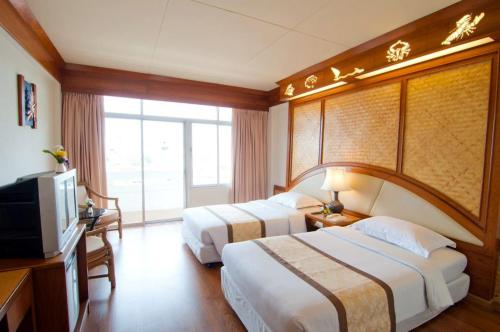 Habitación de hotel con 2 camas y TV en Golden Beach Hotel Pattaya, en Pattaya central