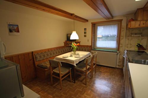 une cuisine avec une table et des chaises ainsi qu'une fenêtre dans l'établissement Ferienwohnung Schiller, à Jonsdorf