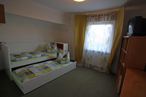 - une chambre avec 2 lits et une fenêtre dans l'établissement Ferienwohnung Schiller, à Jonsdorf