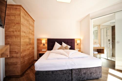 a bedroom with a large bed with white sheets at Amaris Apartments in Ischgl