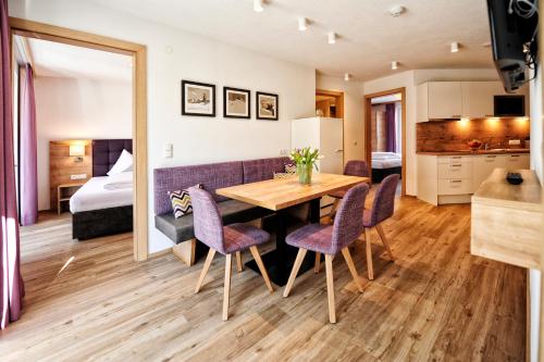 Zimmer mit einem Tisch und Stühlen sowie einem Schlafzimmer in der Unterkunft Amaris Apartments in Ischgl