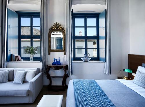 a living room with a couch, chair and a window at Orloff Boutique Hotel in Hydra