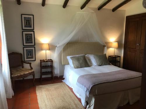 a bedroom with a bed with two lamps and a chair at Herdade D. Pedro in Terena