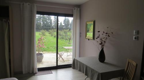 Cette chambre dispose d'une table et d'une porte donnant sur une terrasse. dans l'établissement Safranière des Sorgues, au Thor