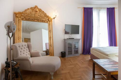 a bedroom with a mirror and a chair and a bed at Hotel Pension Museum in Vienna