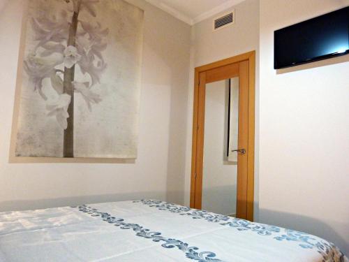 a bedroom with a bed and a television on the wall at Najera Suite in Antequera