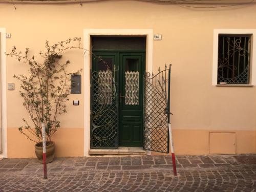 una puerta verde al lado de una casa en Freja, en SantʼAntìoco