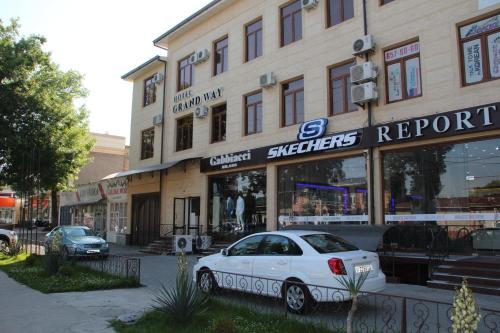 a white car parked in front of a store at Hotel "GRAND WAY" in Tashkent