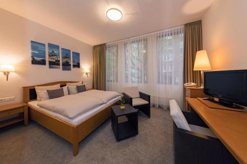 Habitación de hotel con cama y TV de pantalla plana. en Hotel Cristobal en Hamburgo