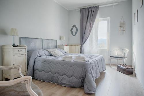 1 dormitorio con 1 cama, 1 silla y 1 ventana en Treinin Guest Rooms, en Gavi