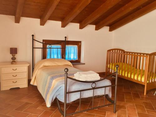 sypialnia z łóżkiem, łóżeczkiem dziecięcym i stołem w obiekcie CASA VACANZA VILLA DeA w mieście Villafranca in Lunigiana