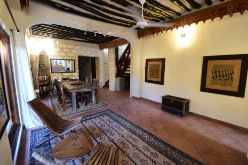 sala de estar con mesa y suelo de baldosa en Tamani Villas, en Matemwe