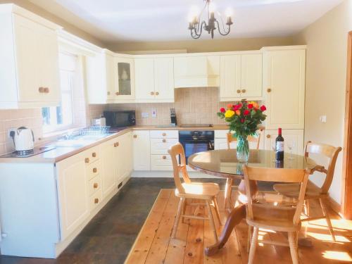 a kitchen with a table with a vase of flowers on it at The-Gables in Donegal