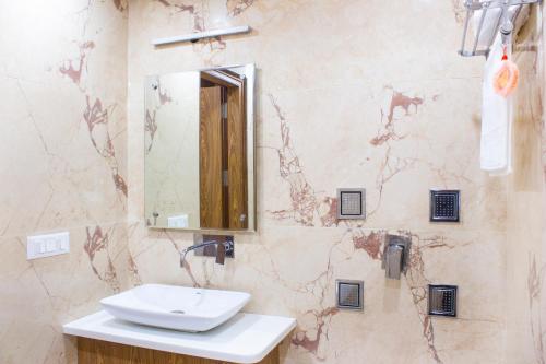 ein Badezimmer mit einem Waschbecken und einem Spiegel an der Wand in der Unterkunft AP Holidays in Neu-Delhi