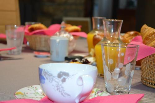 einen Tisch mit einer Tasse Tee und Gläsern darauf in der Unterkunft L'ESCALE DES 2 EAUX in Mortagne-sur-Sèvre